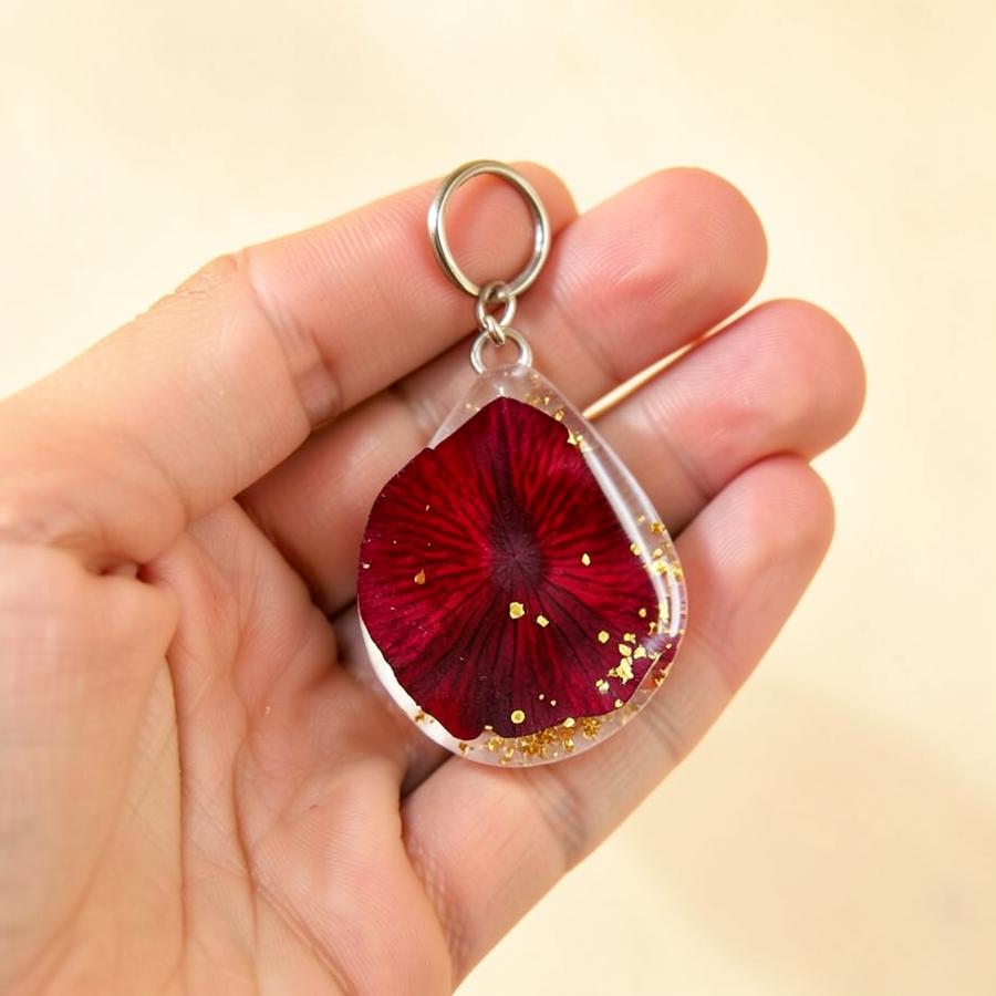 Rose petal resin keychain held in hand